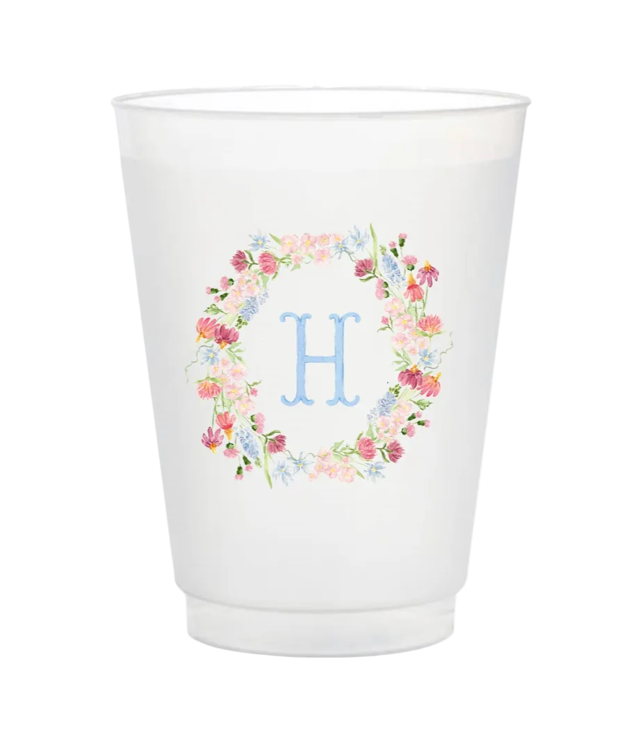 White cup with floral design and letter 'H' on a white background