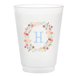 White cup with floral design and letter 'H' on a white background