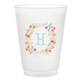 White cup with floral design and letter 'H' on a white background