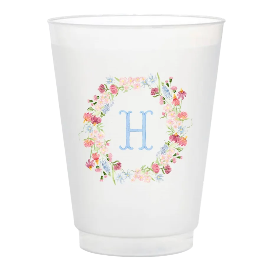 White cup with floral design and letter 'H' on a white background