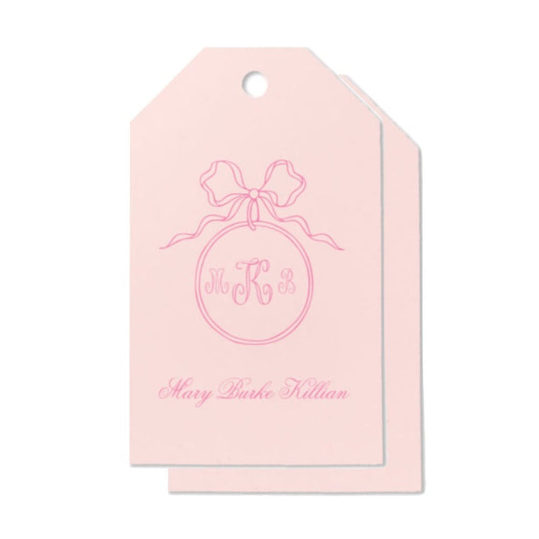 Pink gift tag with a bow and text on a white background