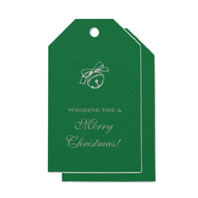 A green Christmas gift tag with a white line-art jingle bell and bow graphic, featuring the text 'WISHING YOU A Merry Christmas!' printed in white, shown on a plain white background.